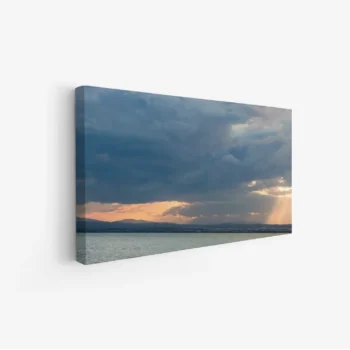 لوحة بحر بألوان دافئة مع غيوم داكنة وأشعة شمس تتسلل، جو هادئ ومريح، لوحات طبيعة، لوحات كانفاس.