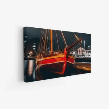 لوحة بحرية لزورق أحمر يضيء تحت أضواء المدينة ليلاً، تعكس الألوان الدافئة على الماء، لوحات طبيعة، لوحات كانفاس.