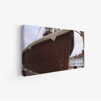 لوحة بحرية لسفينة خشبية تقف بفخر تحت سماء غائمة، ألوان دافئة تعكس الأجواء البحرية، لوحات جمادات ومعالم، لوحات كانفاس.