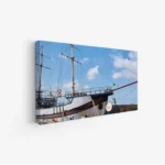 لوحة بحرية تظهر سفينة تقليدية تحت سماء زرقاء مع سحب بيضاء، تعكس أجواء هادئة، لوحات طبيعة، لوحات كانفاس.
