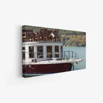 لوحة بحر تعكس جمال قارب خشبي محاط بمياه زرقاء وصخور خضراء، أجواء هادئة ومريحة، لوحات طبيعة، لوحات كانفاس.