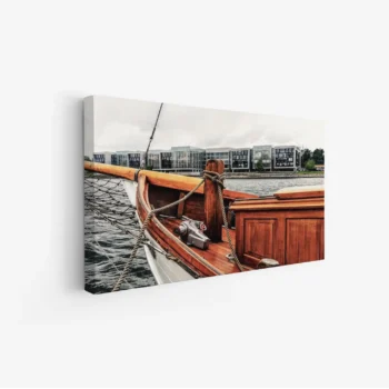 لوحة بحرية تظهر قاربًا خشبيًا يرسو على مياه هادئة مع مباني حديثة في الخلفية، ألوان دافئة وجو مريح، لوحات طبيعة، لوحات كانفاس.
