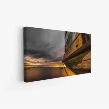 لوحة بحرية تظهر قاربًا قديمًا تحت سماء غائمة وألوان غروب دافئة، أجواء هادئة ومريحة، لوحات مناظر طبيعية، لوحات كانفاس.