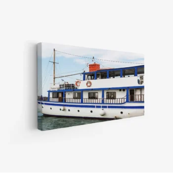 لوحة بحر تظهر قاربًا أبيض مزينًا بالأزرق تحت سماء صافية، تعكس أجواء هادئة، لوحات جدارية، لوحات كانفاس.