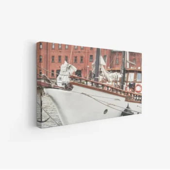 لوحة بحرية تظهر قاربًا أبيض يرسو بجانب مباني حمراء، أجواء هادئة ومريحة، لوحات طبيعة، لوحات كانفاس أنيقة