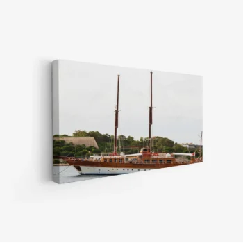 لوحة بحرية تظهر يختًا خشبيًا جميلًا وسط مياه هادئة وأشجار خضراء، أجواء مريحة، لوحات مناظر طبيعية، لوحات كانفاس.